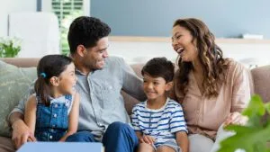 Father, daughter, mother, son, enjoying interacting on sofa