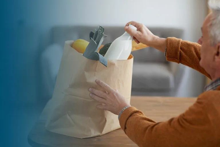 senior man unpacking groceries at home