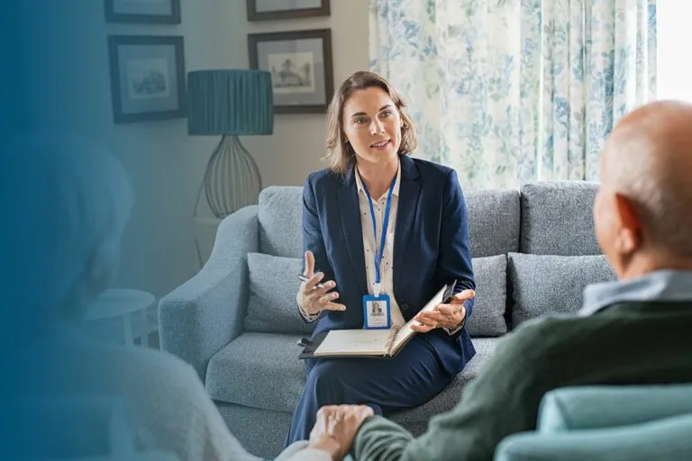 social worker talking to senior couple at home