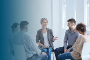 psychotherapist and four clients sitting in spacious bright office