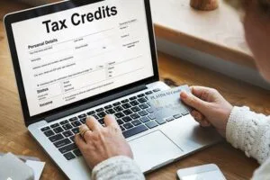man sitting at laptop working on tax credits claim