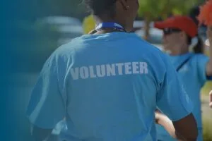 woman in blue t shirt with text saying volunteer on reverse
